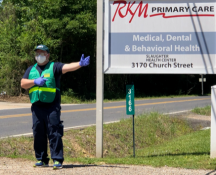 A volunteer directing traffic to RKM Primary Care