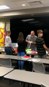 3 people standing by a table