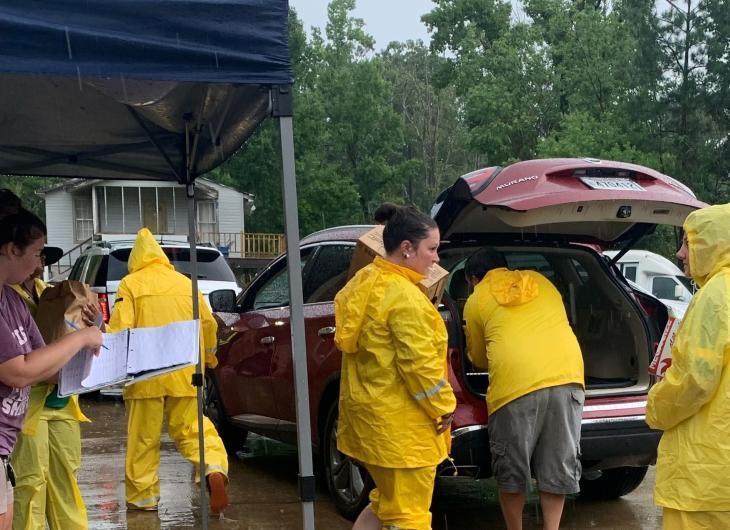 Volunteers loading a car in the rain